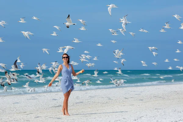 Junge schöne Frau beobachtet die Möwen fliegen — Stockfoto