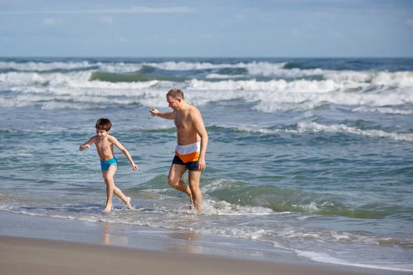 Padre e hijo divirtiéndose en una playa tropical — Foto de Stock