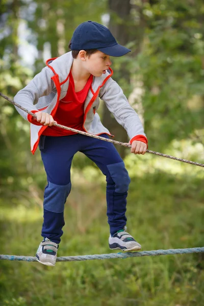 Söt liten pojke har roligt utomhus klättring på lekplats — Stockfoto