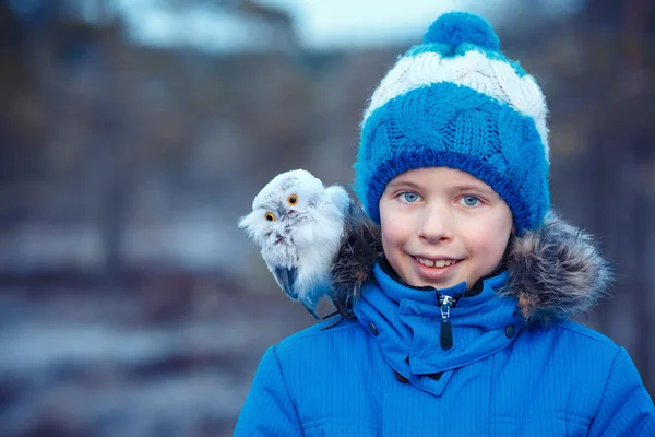 Garçon mignon avec jouet hibou sur l'épaule dans la forêt d'hiver — Photo