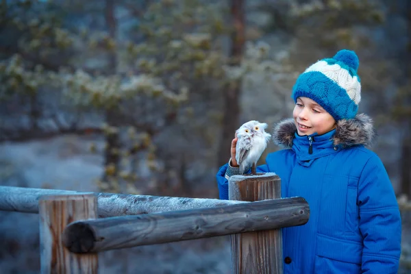 Rapaz bonito com coruja brinquedo no ombro na floresta de inverno — Fotografia de Stock