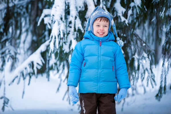 Bonito menino brincando na floresta de inverno — Fotografia de Stock