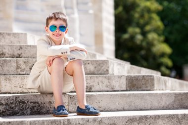 Güzel bir takım elbise ve gözlük içindeki küçük çocuk. Çocuk portre