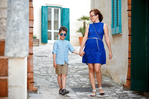 Junge Mutter und ihr Sohn gehen draußen in der Stadt — Stockfoto