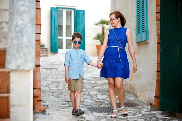 Joven madre y su hijo caminando al aire libre en la ciudad — Foto de Stock