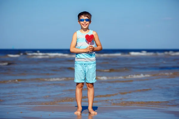 Cute little boy holding candy heart — Stock Photo, Image