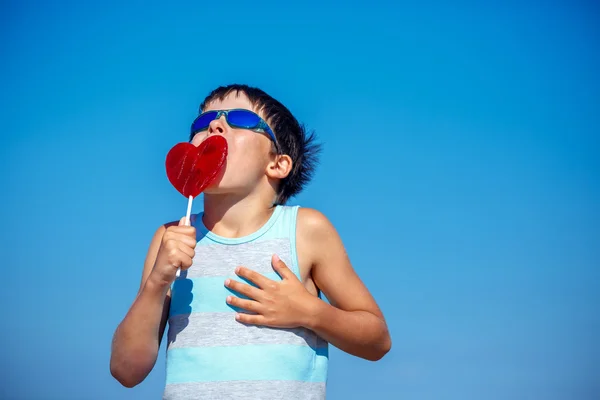 Lindo niño sosteniendo corazón de caramelo —  Fotos de Stock