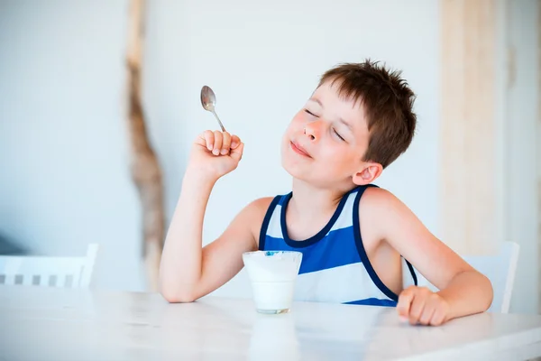 Sorrindo menino comendo delicioso iogurte — Fotografia de Stock