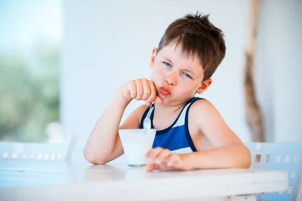 Menino sorridente se recusa a comer iogurte delicioso — Fotografia de Stock