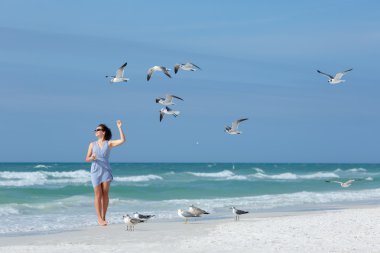 Genç kadın martılar tropikal Beach, Florida besleme