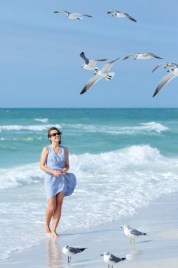 Genç kadın martılar tropikal Beach, Florida besleme