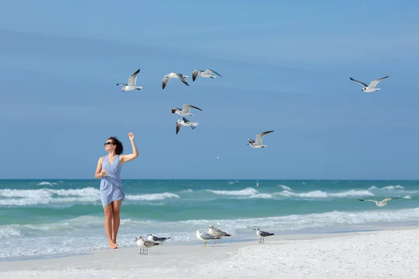 Mladá žena krmení racků na tropické pláži, Florida — Stock fotografie