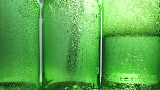 Kondenzátumok cseppjei a zöld sörösüvegeken. — Stock videók