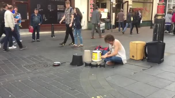 Soho, Londýn, Velká Británie: Pouliční muzikant vystupuje v Čínské čtvrti. Bubeník hraje o peníze na ulici. — Stock video