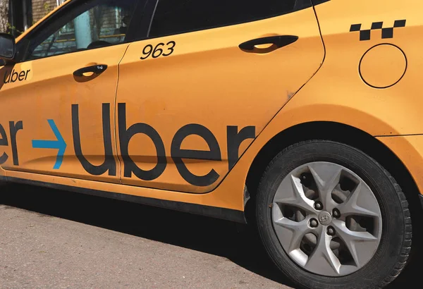 stock image Moscow, Russia: Yellow taxi with Uber logo on the street. Yellow taxi cab with checker pattern. Uber taxi cab. Cheap trip.