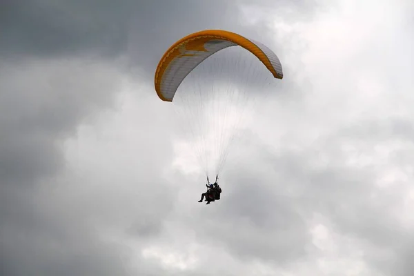 Paragliding in bad weather in the Moscow region. The cloudy and moody sky doesn\'t scare brave parachute-jumpers (skydivers). You only live once. Seize the day.