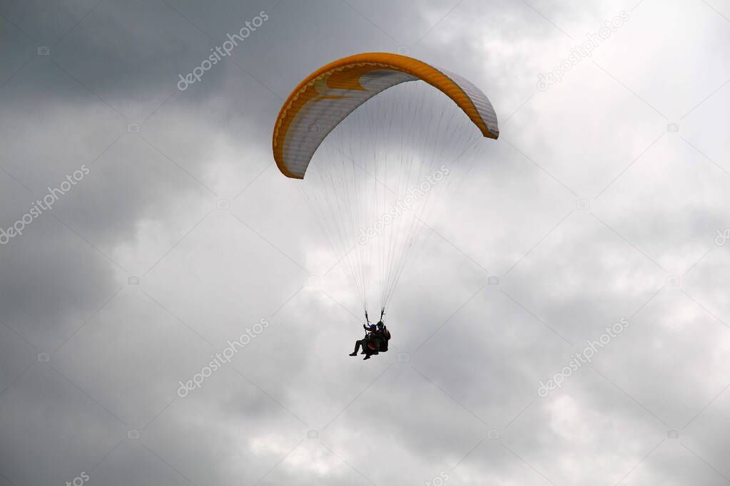 Paragliding in bad weather in the Moscow region. The cloudy and moody sky doesn't scare brave parachute-jumpers (skydivers). You only live once. Seize the day.