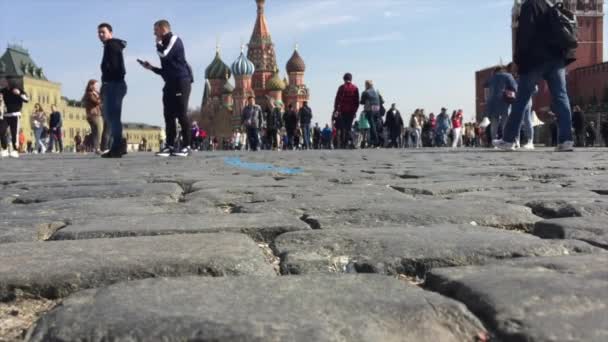 Lidé kráčející po Rudém náměstí dláždění kamenem Gabbro-Diabase z Karelia Republic. Je to velmi hustý kámen, odolný vůči přírodním a mechanickým dopadům. — Stock video
