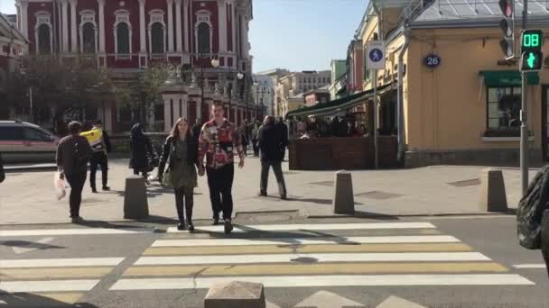 Moskou, Rusland - 04.17.21: Overstekende voetgangers op een stoplicht kruispunt van Pyatnitskaya Street en Klimentovsky Lane. Mensen die de weg oversteken — Stockvideo