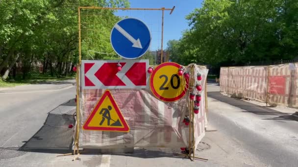 Moscow: Roadworks scene in the city on a sunny day. Road warning symbols: Roadwork ahead sign, detour on the right sign, speed limit. Driveway repairing works. 4K video 3840x2160 — 图库视频影像