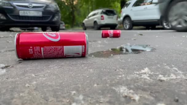 Moscú, latas rojas de Coca Cola en la carretera, residuos de metal en la calle. Bebida descartada lata de bebida no alcohólica. Latas de coca. Basura clásica de latas de Coca Cola, vídeo 4K 3840x2160 — Vídeos de Stock