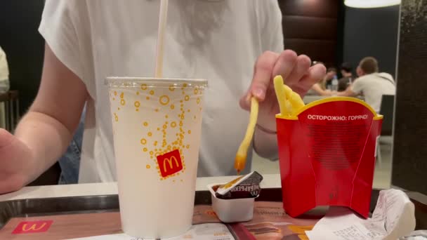Moskau: Kartoffelfrites von Hand essen im McDonald 's Restaurant. Die Hand der Frau taucht Pommes in Barbecue-Soße. Fast food. 4K-Video 38402160 — Stockvideo