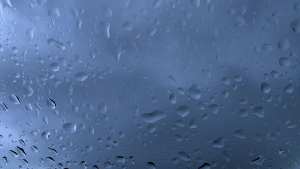 雨水が車の窓ガラスに落ちて曇りの空に落ちる 雨のビデオが窓ガラスに落ちる — ストック動画