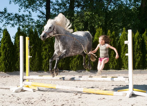 Menina pulando com pônei — Fotografia de Stock