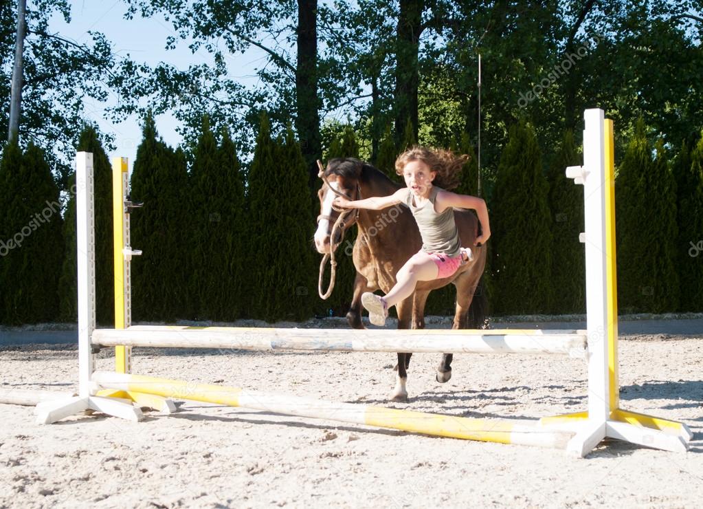 Girl training jumping with pony