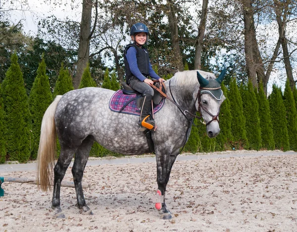 Liten flicka rider på roan ponny — Stockfoto