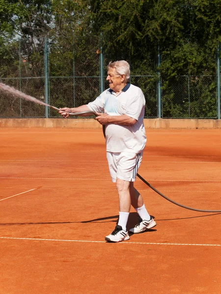 노인 sprinklig 테니스장 앞 — 스톡 사진