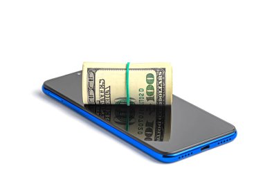 Beyaz arka planda elastik bant ve cep telefonuyla bağlanmış bir tomar dolar..