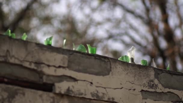 Glasscherben an der Wand. Ein Betonzaun mit Glasscherben wirkt abschreckend auf die Menschen. Abschreckung gegen Wohnungseinbrüche. — Stockvideo