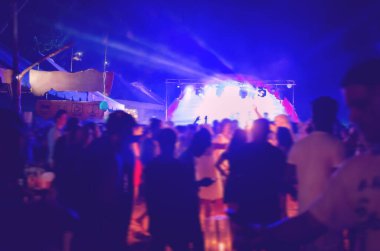 Açık hava gece kulübü veya konserinde bulanık insanlar vardı. Bulanık hareket halinde odaklanmış bir fotoğraf. Metin için boş yer, kopyalama alanı. 