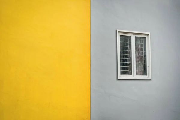 Yellow and gray outdoor wall with window. Outside wall duotone color.