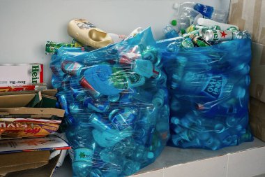 Ayrı ayrı atıklar. Kullanılmış plastik şişeler, metal kutular ve karton ambalajlar çöp torbalarında toplanır. Yeşil kavramı takip ederek atığı azaltmak. Vietnam, Nha Trang: 2020-12-14.