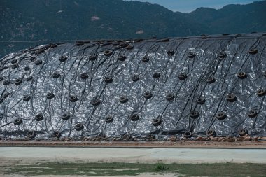 Havadan gelen koruyucu bir filmle kaplı mineral yığını. Açık alanda malzeme deposu inşa ediliyor. 