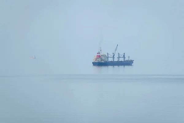 Грузовой Корабль Стоящий Якоре Море Туманным Утром Море Сливается Горизонтом — стоковое фото