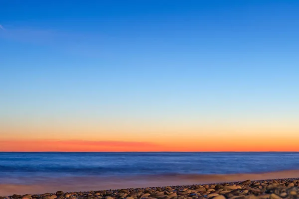 Beautiful abstract sunset horizon sky tone blurred background, blue orange pattern. Clear gradient sky at sunset over the sea.  Defocused photo with blur in motion.