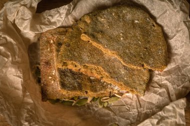 Elle yapılan taze ekmek ya da tortilla ve olgun buğday kulağı parşömen kağıdı üzerinde ahşap masa üzerinde