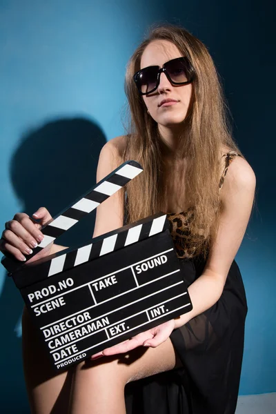 Schöne Frau hält einen Filmklatscher in der Hand. — Stockfoto