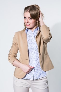 Hafif bej ceketi giyen güzel genç sarışın