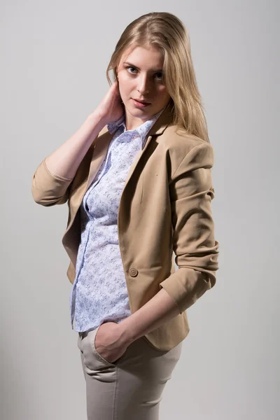 Beautiful young blonde in a light beige jacket — Stock Photo, Image