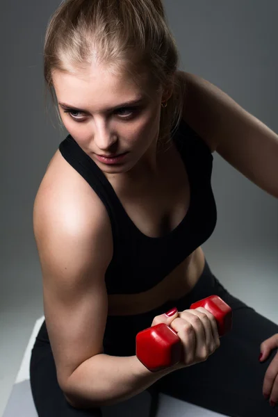 Atletik genç bir kadın fitness egzersiz dumbbells ile yapıyor — Stok fotoğraf