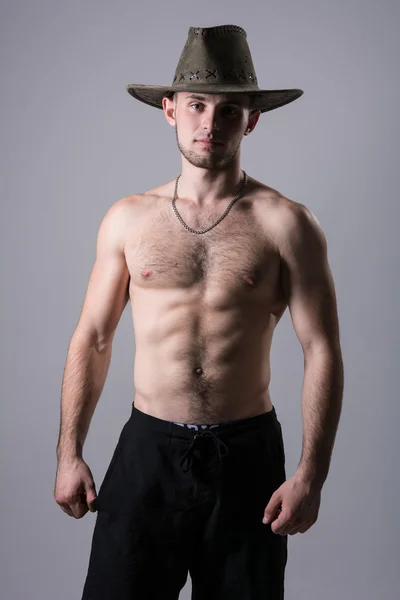 Handsome man posing with a cowboy hat — Stock Photo, Image