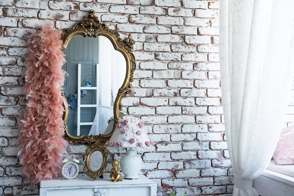 Mirror in a gilded frame with curly boa — Stock Photo, Image