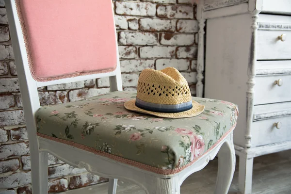 Мужская шляпа лежит на розовом стуле против — стоковое фото