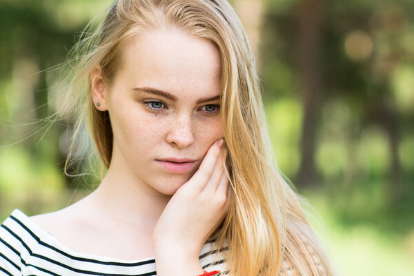 Close-up of thoughtful girl in a striped dress