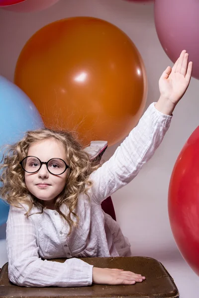 Chica en gafas con la mano levantada quiere preguntar —  Fotos de Stock