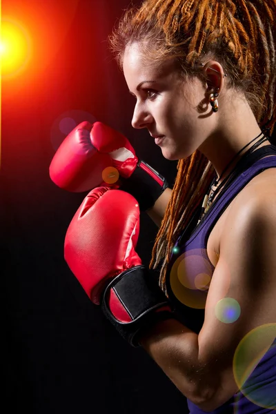 Vacker flicka med röd boxningshandskar, dreadlocks på en svart bac — Stockfoto